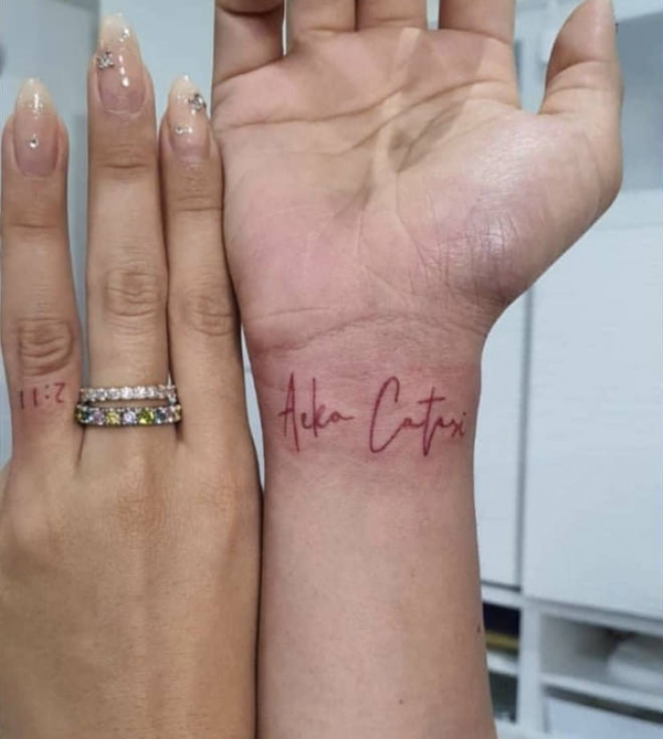 Ammika Harris  tattoos  the name  of her Aeko amid Chris 